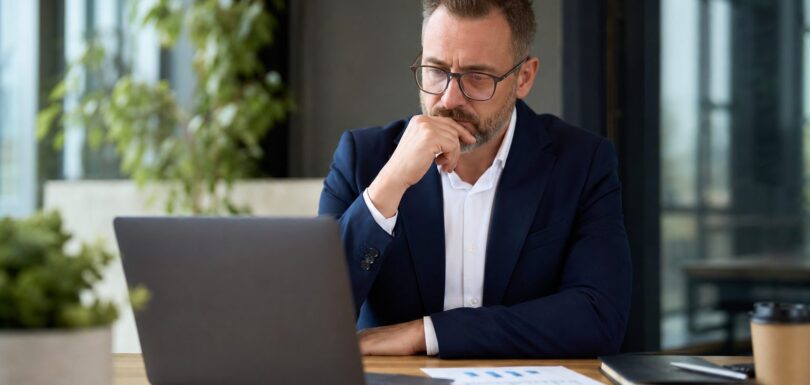 Business owner reviewing analytics on laptop in modern office