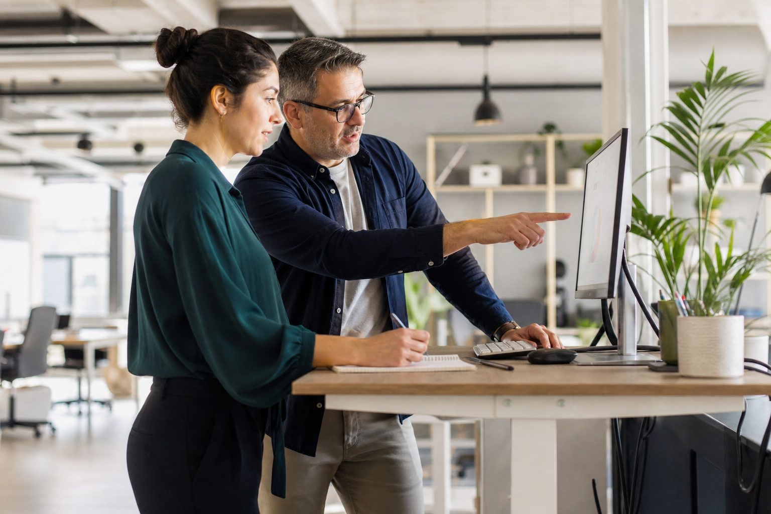 Two marketing professionals collaborating on AI search strategy at a standing desk