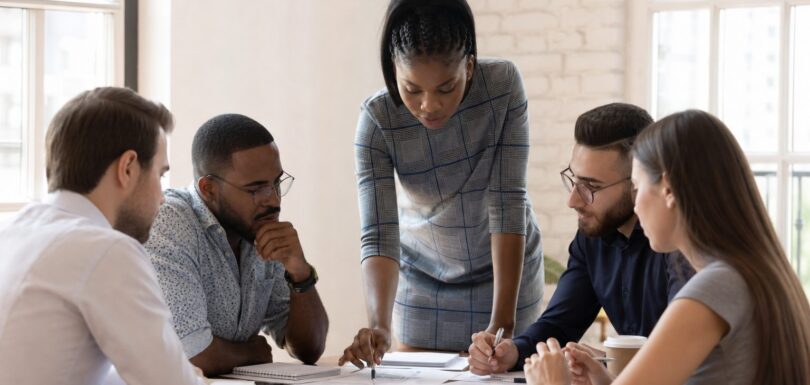 Business team collaborating in a meeting room, strategising around a table