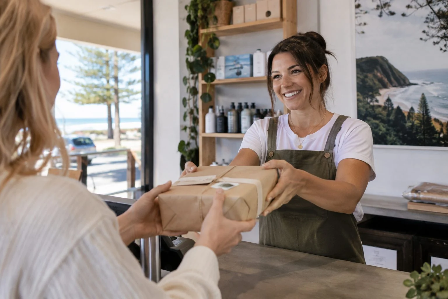 Shopfront owner handing a click and collect parcel to a customer in Burleigh Heads