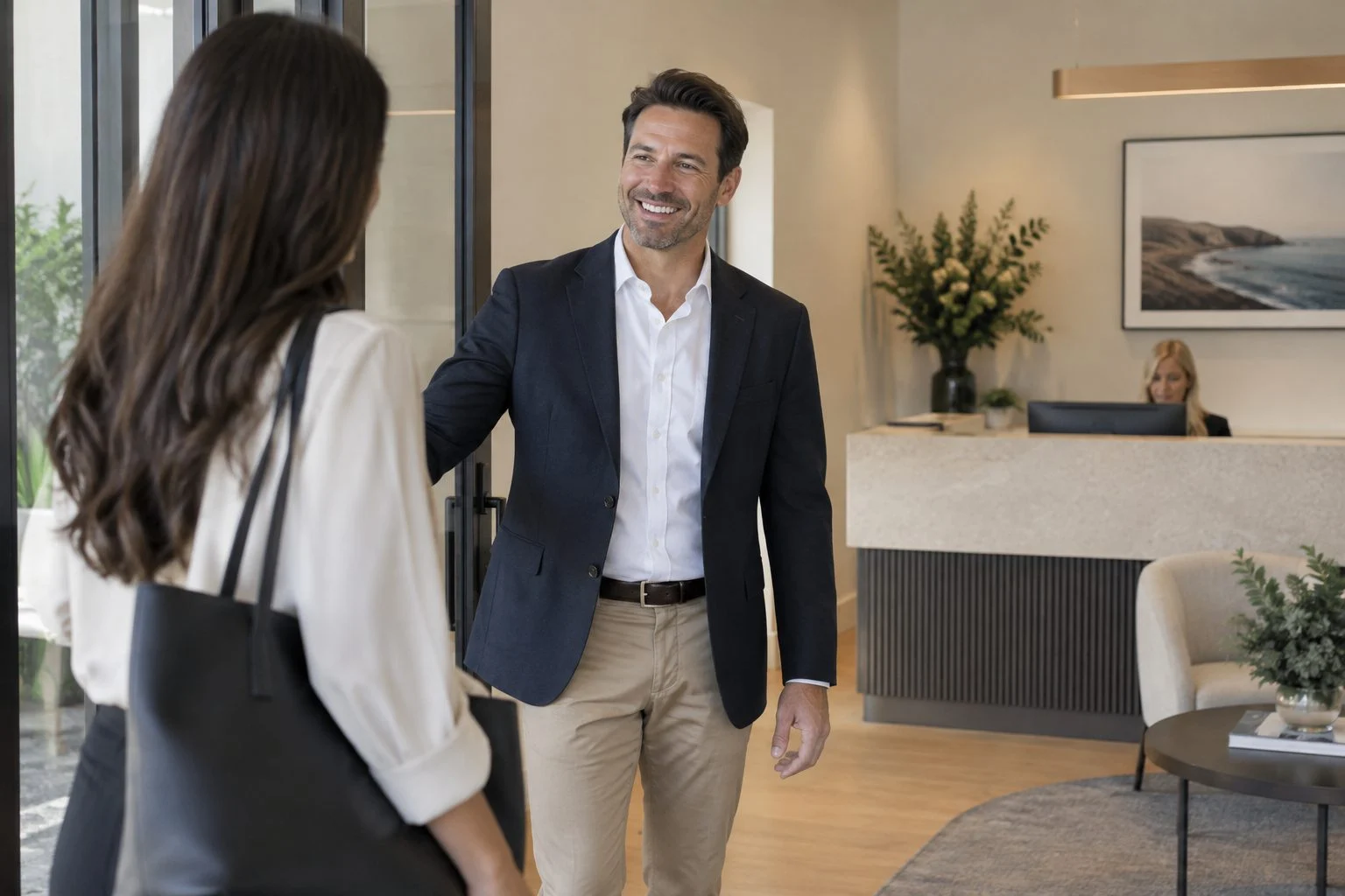 Adviser greeting a client at the reception of a boutique financial planning office