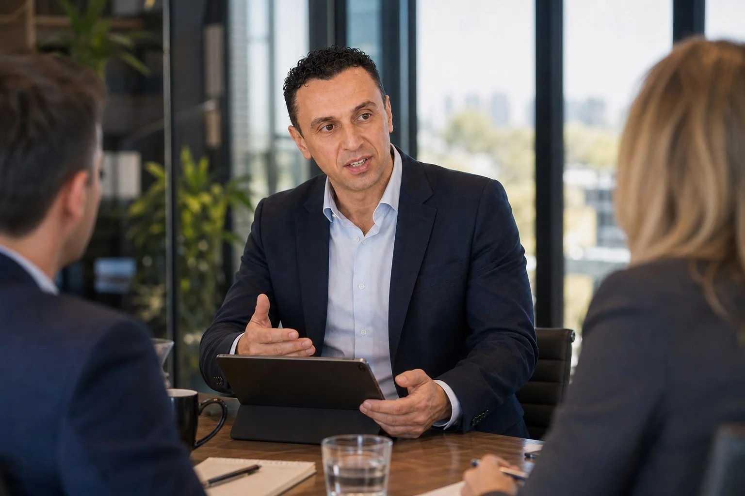 Richie Zengoski talking two small business owners through a tablet in a meeting room